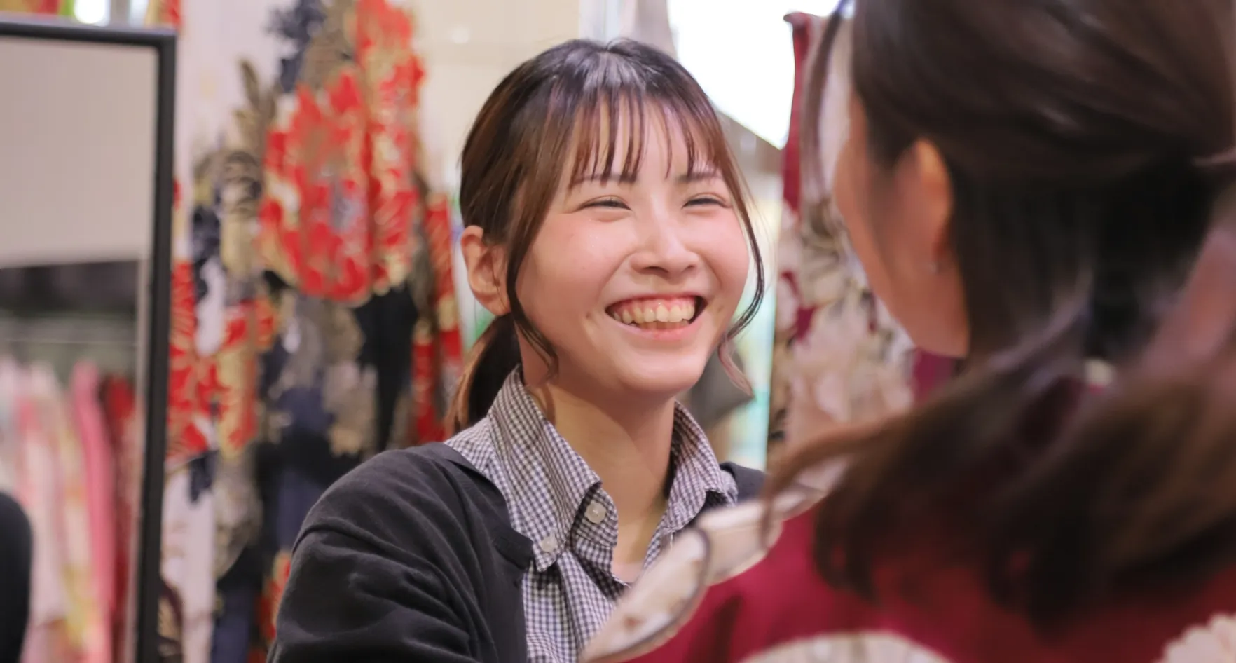 美容部Eさんのインタビュー写真（着物店で笑顔でお客様と対話）
