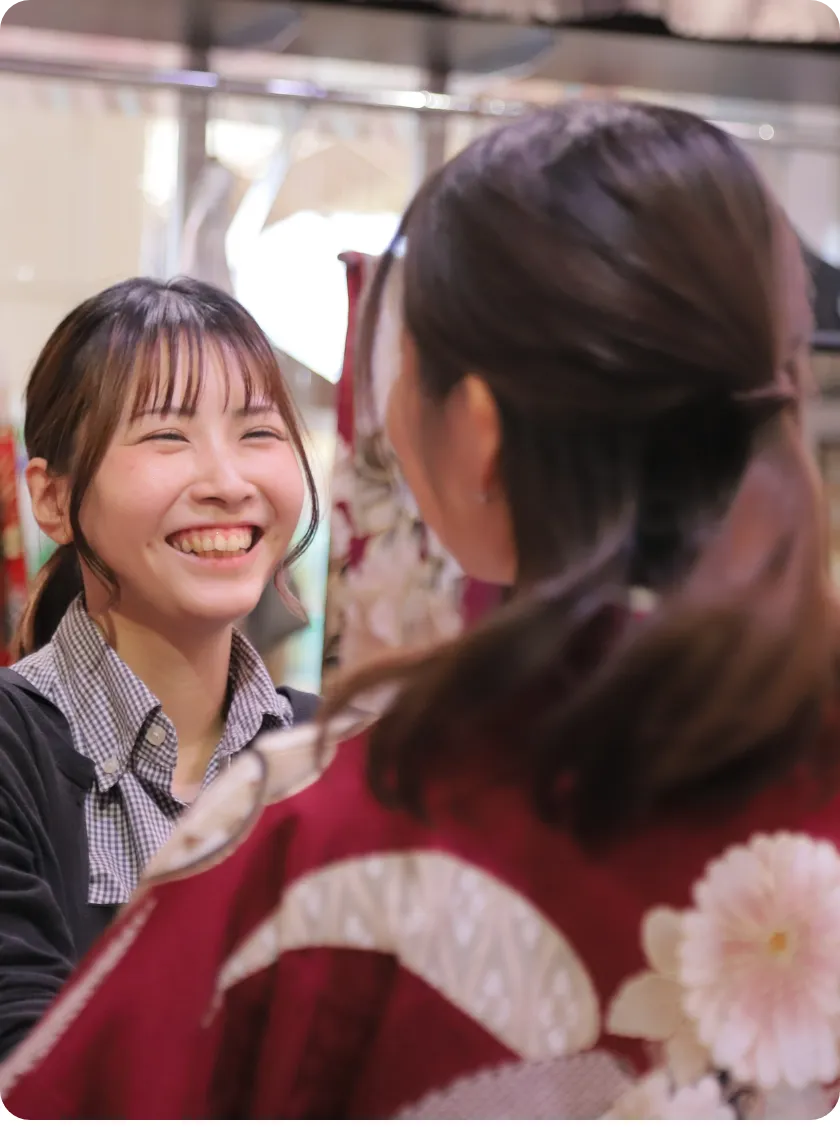 着物を着たお客様と笑顔で話すスタッフ